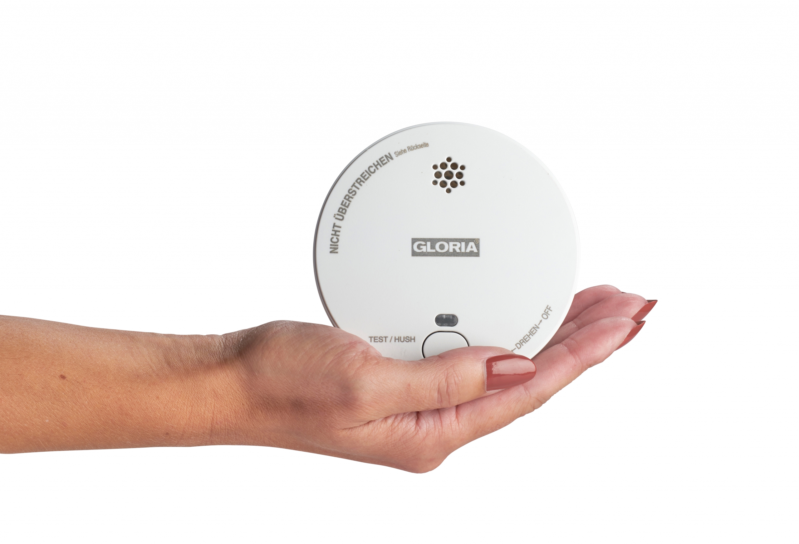 Weißer Rauchmelder der Firma GLORIA, Modell R1, gehalten in einer flachen Damenhand.